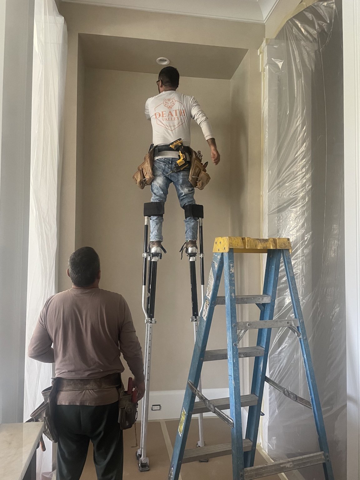 Crew applying drywall joint compound